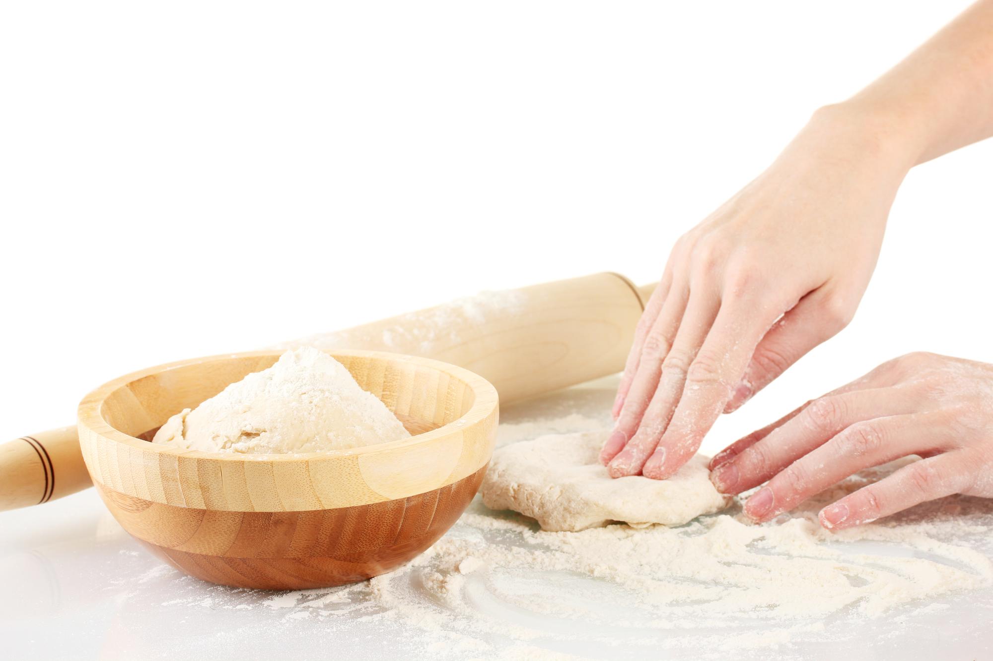 Instructor hands kneading dough in soft light